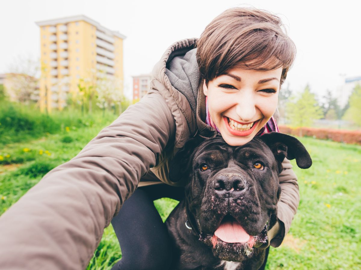 A selfie taken outside with a dog and their owner.