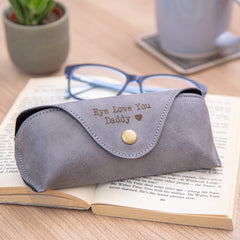 personalised glasses case engraved with 'Eye Love You Daddy' and a love heart, placed on top of a book on a table with accessories