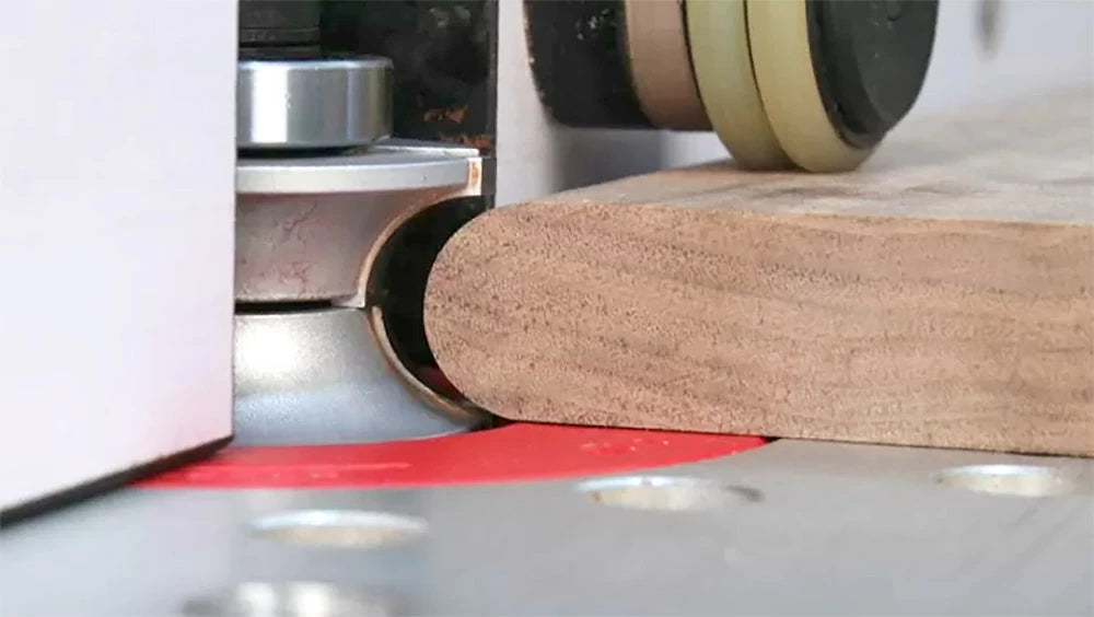 Routing a half-round bullnose profile on the edge of a workpiece.