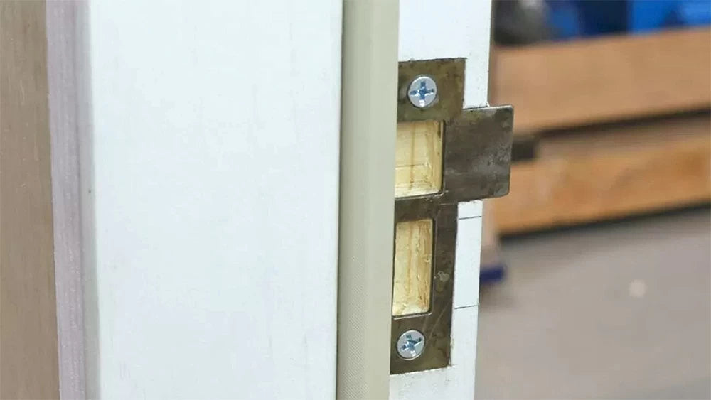 A shop-built jig provides support for the router. The plywood blocks act as stops to limit the length of the mortise to the proper size.