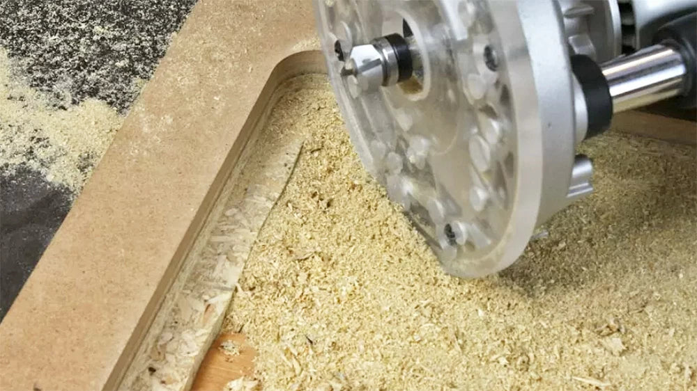Rout the rabbet in several passes until the router plate sits just below the surface of the tabletop.