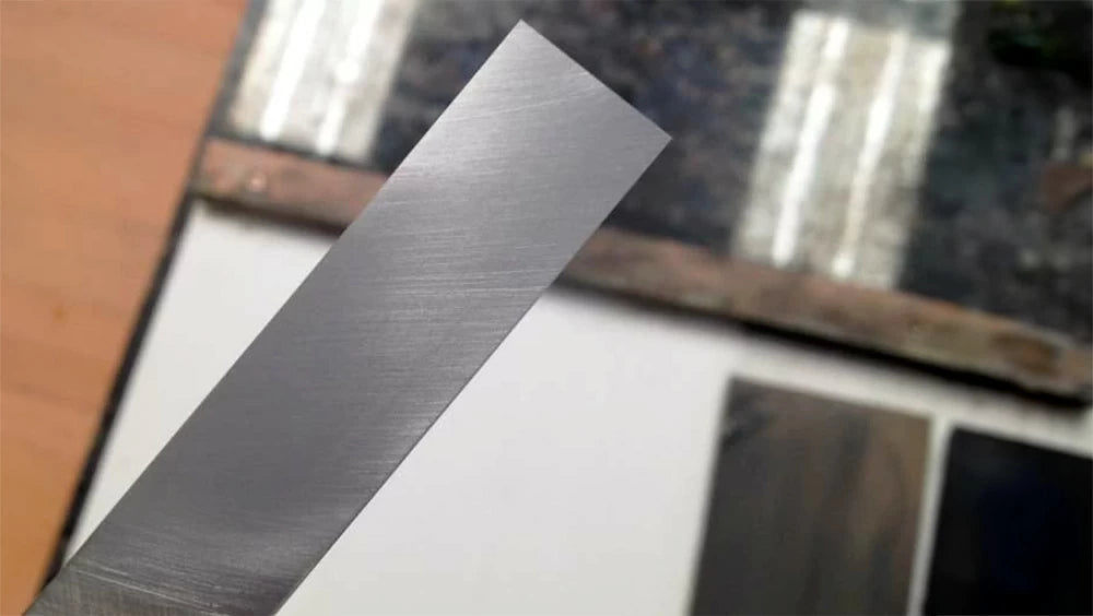 You are looking for an even scratch pattern across the back of your chisel.