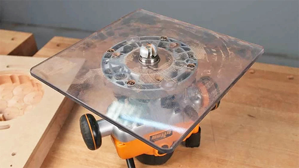 A large Router Base plate and a Bowl and Tray bit with a bearing are used to remove the material left by the Forstner bit, and will leave a nice radius in the corners of the tray.