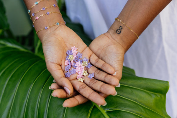 Hands holding our beaded glass stars from our Gemini Star Earrings