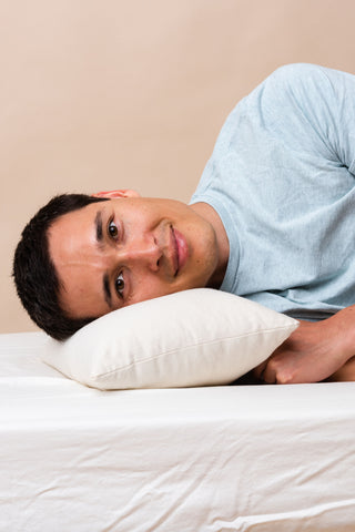 Man sleeping on ComfyComfy mini buckwheat hull pillow for side sleepers made in the USA