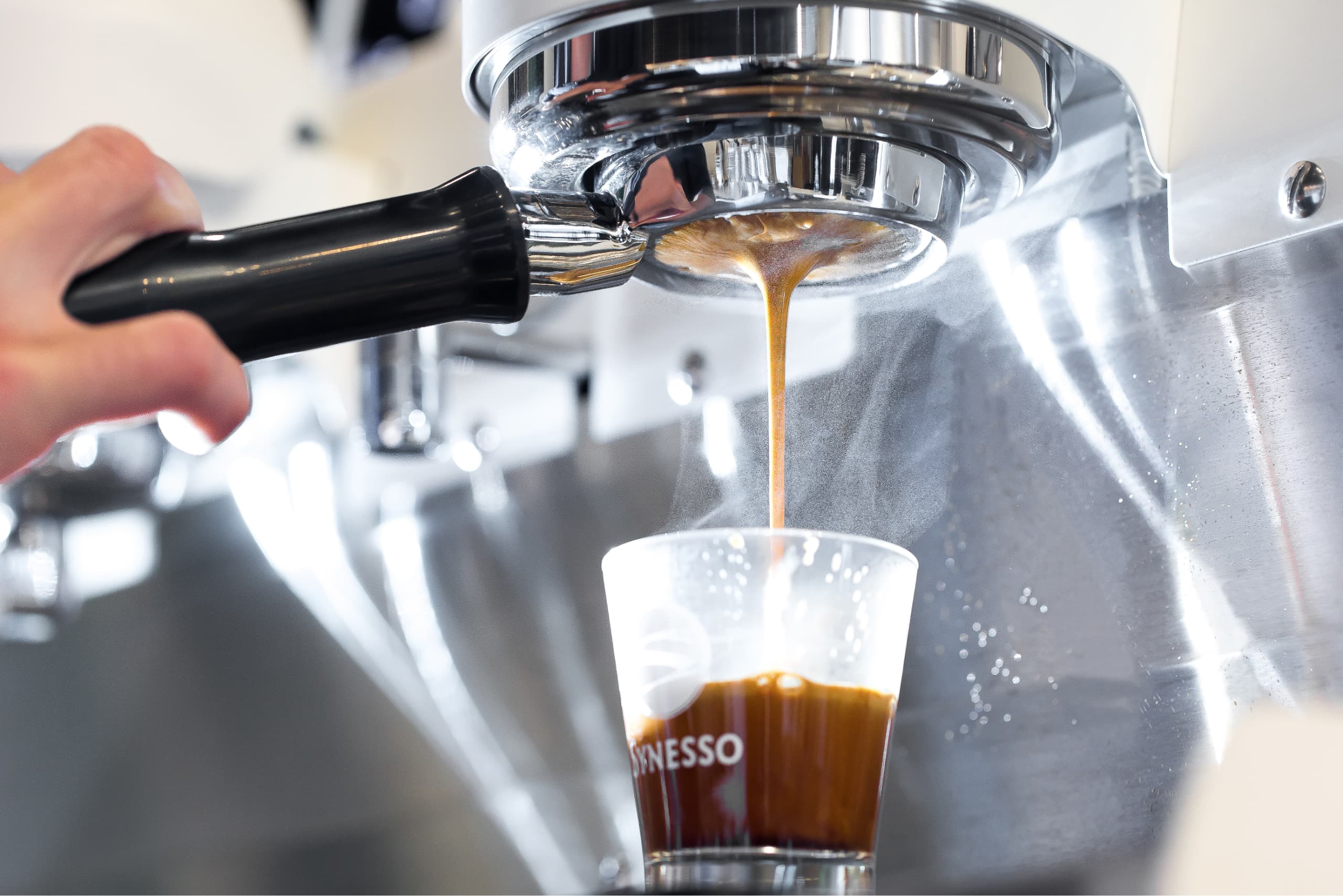 Undershot of an espresso pour with crema visible from the portafilter