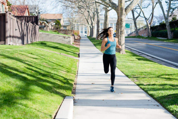 Athletic woman running down a sidewalk 