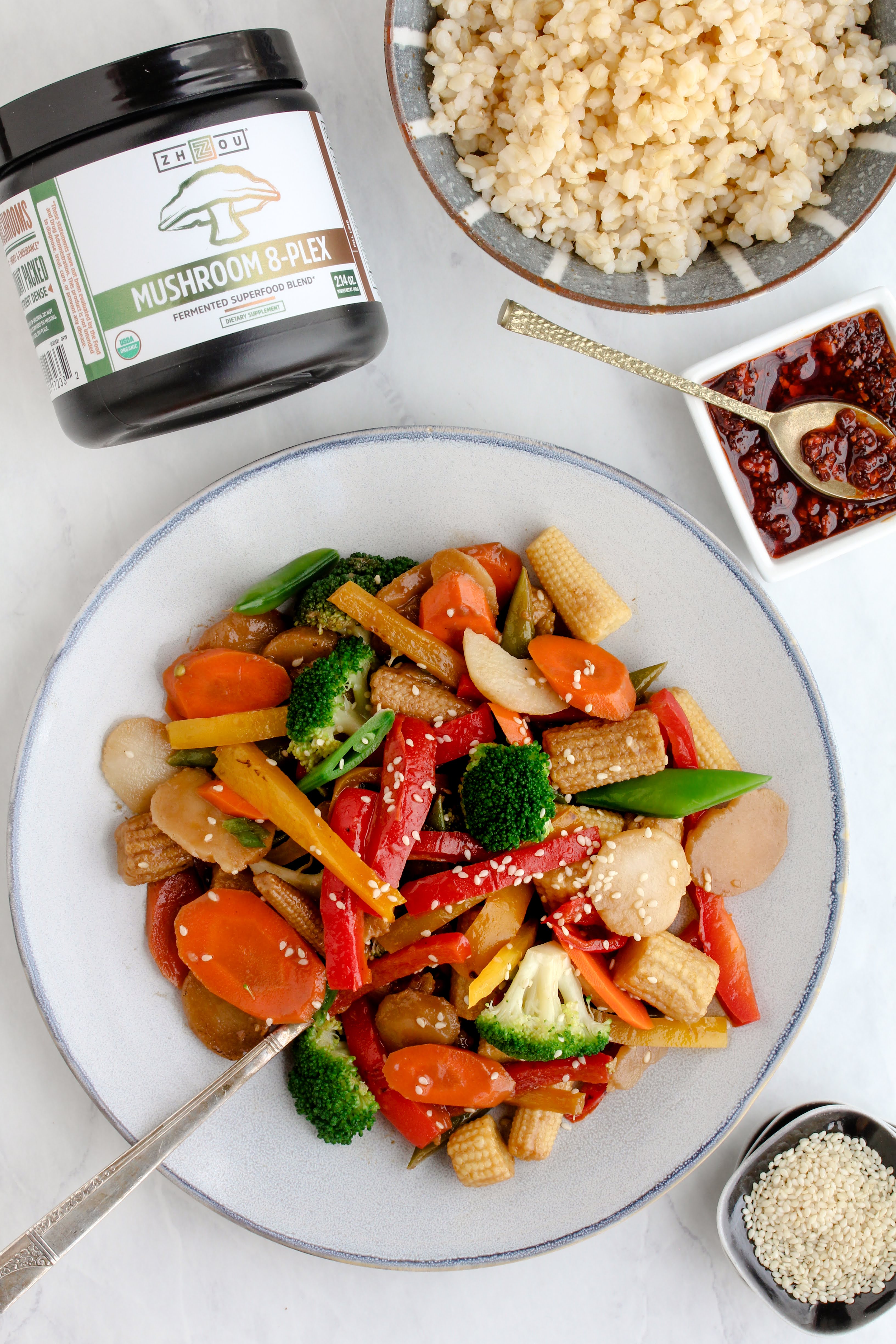 8-plex superfood blend placed next to a brightly colored bowl of stir fry vegetables