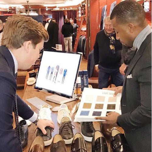 A customer selecting a personalized color for custom-made men's shoes to match his business wardrobe.