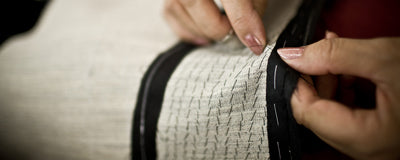 Luxury interior lining being sewn into a made-to-measure men's jacket.