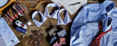 A tailor's worktable showing luxury fabrics and threads.