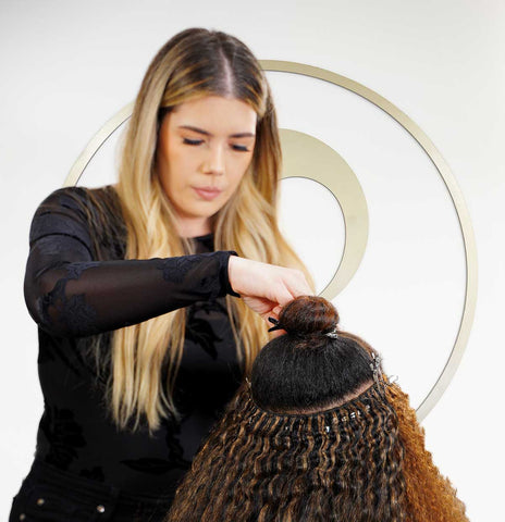 Stylist installing hair extensions