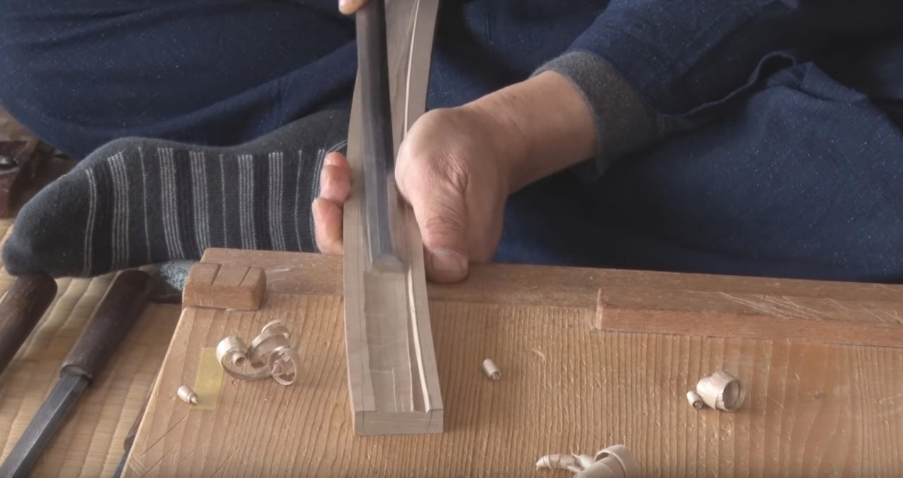 man shaping a scabbard