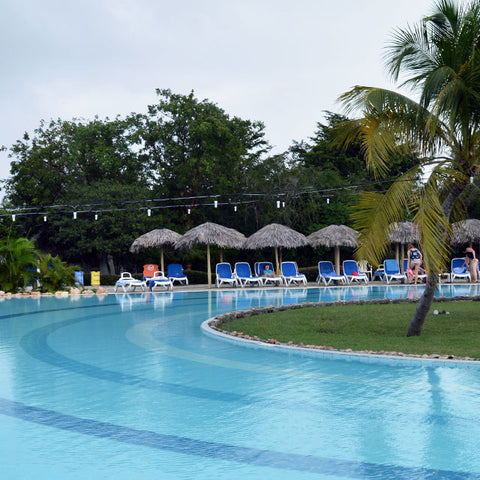 Our spot by the pool, bright microfiber travel towel snapped onto the back of our chairs.