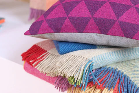 A colourful stack of woollen throws and cushions at Ink & Brayer, nz
