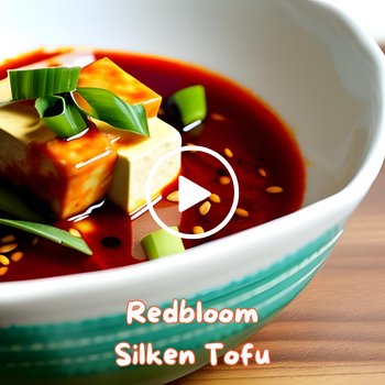 Bowl of silken tofu with spring onions in a red sauce.
