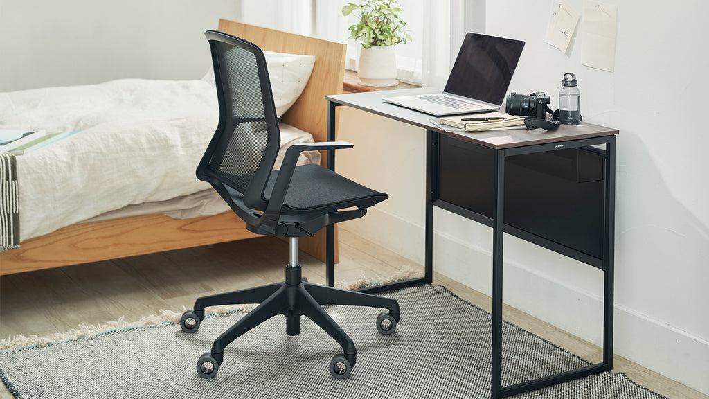 black mesh chair and simple work desk in bedroom