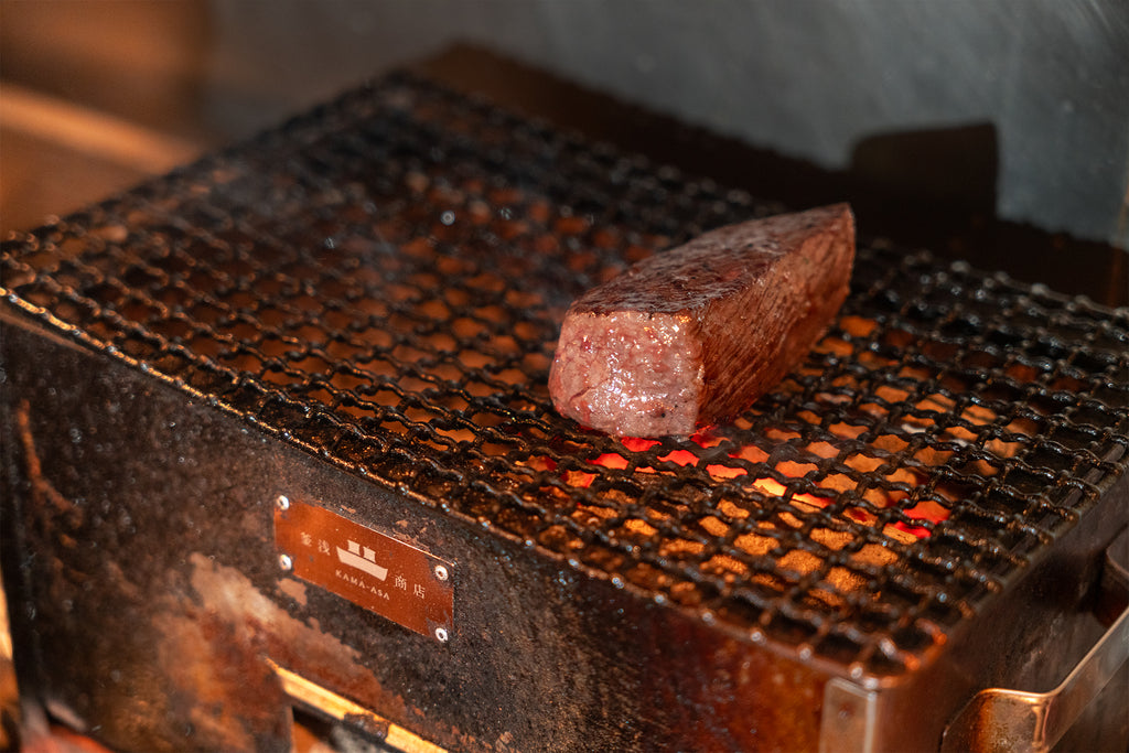 炭火焼ロースターで肉を焼いている