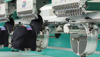 Tajima multihead embroidery machine sewing intricate designs on a cap. Colorful threads, precise stitching, and advanced technology combine to create professional embroidery