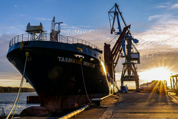 Tintas marítimas. Navio no estaleiro com o pôr do sol ao fundo