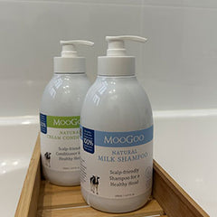MooGoo Milk Shampoo & Cream Conditioner sat on a wooden tray in a bathroom.