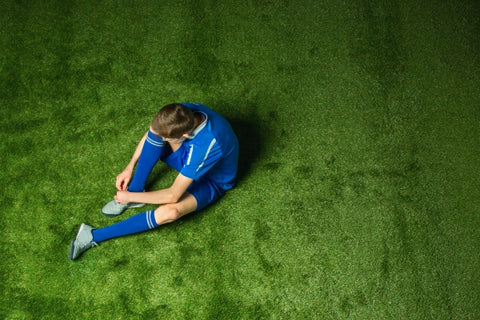 boy-soccer-player-sitting-green-grass