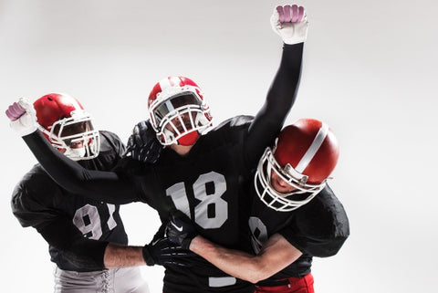 three-american-football-players-posing-white-space