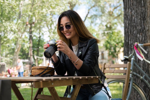 woman-synthetic-leather-jacket-using-camera-while-outdoors