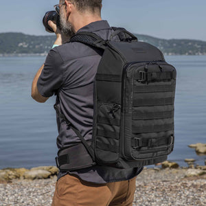 photographer shooting on a beach with Tenba Axis V2 20L Backpack