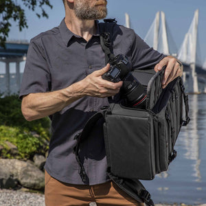 Photographer using the side access of the Tenba Axis V2 20L Backpack