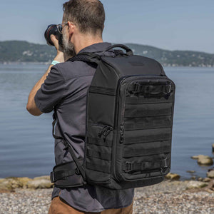 photographer shooting pictures on a beach with Tenba Axis V2 24L backpack