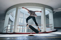 skateboarding kick flipping in parking garage