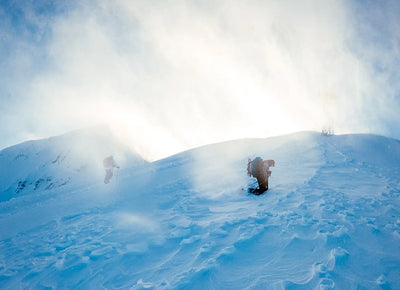 two climbers on the side of a snowy mountain