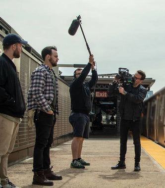 film crew recording on train station platform