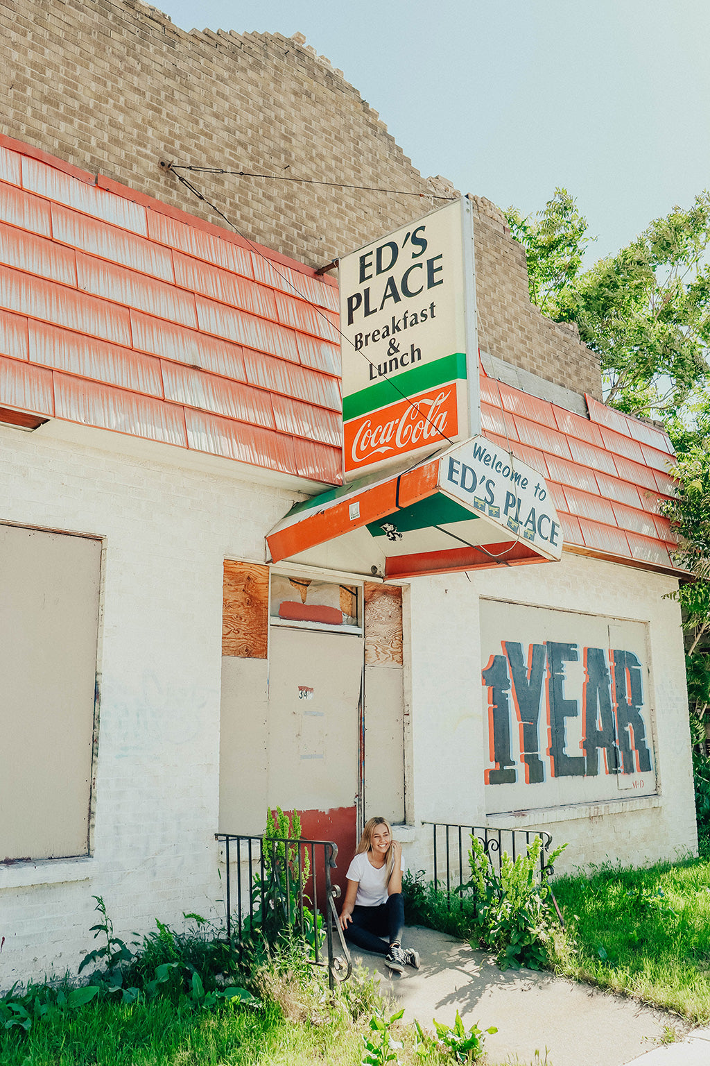 Image of girl sitting under restaurant sign taken with Canon eos rebel SL3 