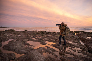photographer shooting sunset on the coast