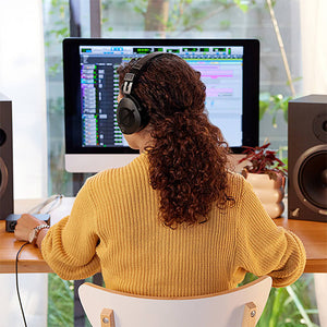 Built For Creative Endurance - Woman wearing headphones working at a computer