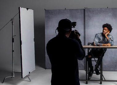 behind the scenes showing the scrim jim Clamp on set holding up the reflector