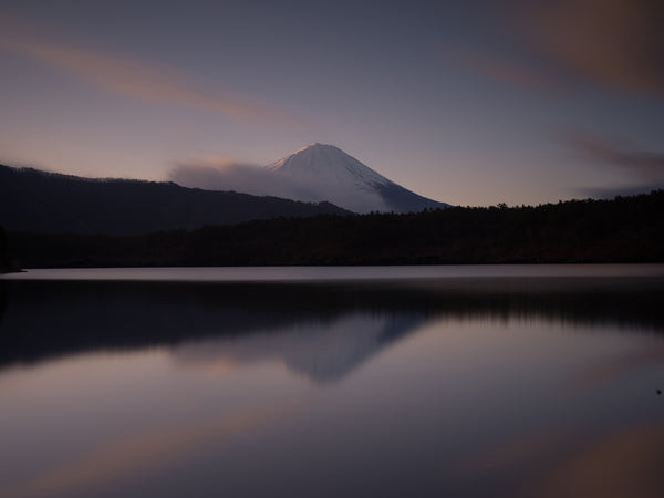 Sunset image of mountain behind a smooth lake