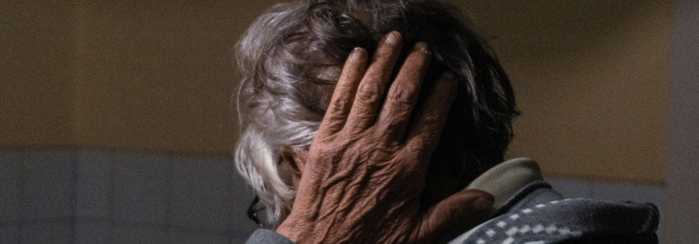 Elderly woman holding the back of her head