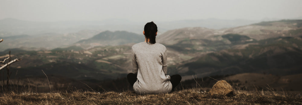 Young woman is meditating in nature