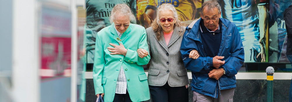 Three Elderly People walking together supporting each other