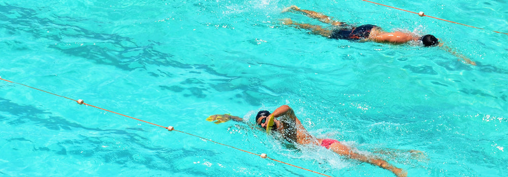 Two young males swimming in a pool