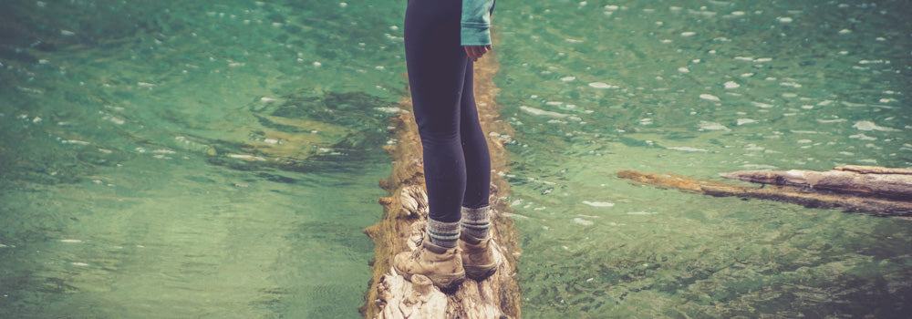 Woman balancing on a tree above water