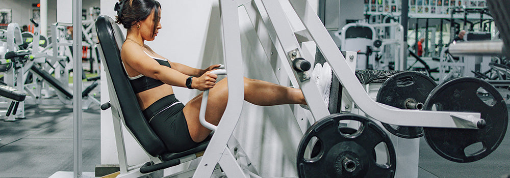 Woman doing leg press exercises in gym