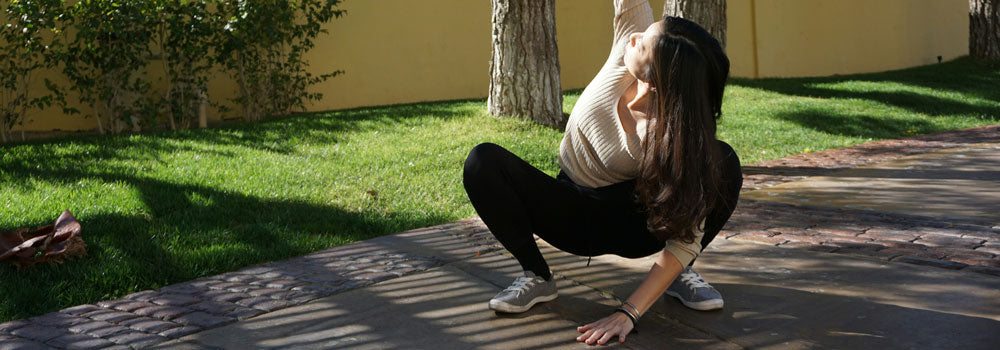 Young lady doing a squat stretch in a beautiful outdoor setting