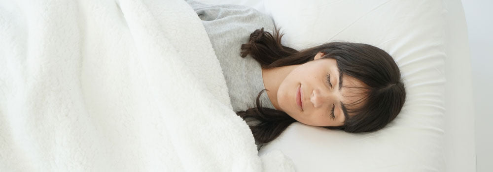 Young woman sleeping with a white fleece blanket