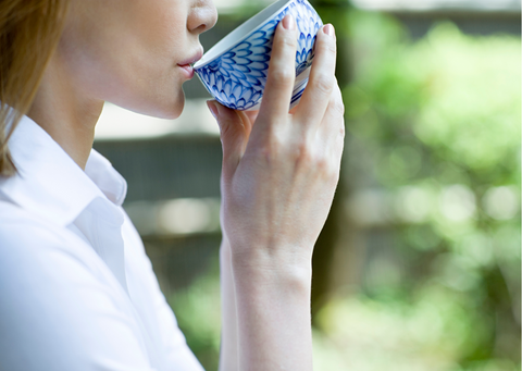 a woman enjoying a sip of lavender tea