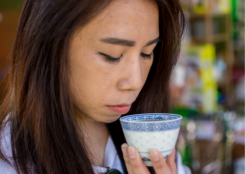 a woman having a taste of black tea