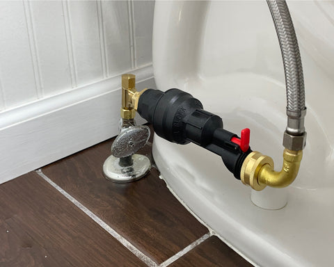Mechanical water block installed on a toilet in a horizontal plane. The water block has fittings to connect to a water shutoff supply valve and a supply hose. This is a safety device that can be used to stop the flow of water to the toilet in the event of a leak or other problem.
